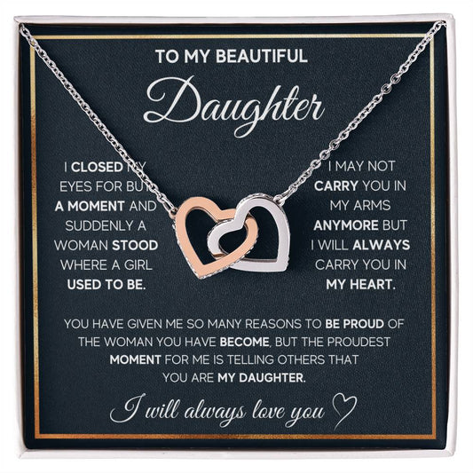 A "To My Daughter, I Will Always Carry You In My Heart" Interlocking Hearts Necklace adorned with cubic zirconia crystals presented in a box featuring a sentimental message by ShineOn Fulfillment.