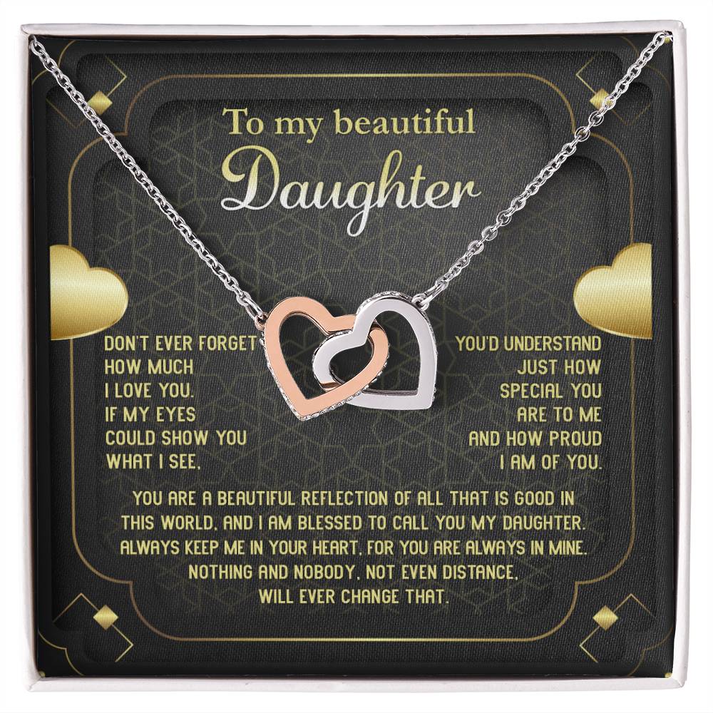 The "To Daughter, Beautiful Reflection - Interlocking Hearts Necklace" features an 18k yellow gold finish and is presented on a card that conveys a heartfelt message of love, pride, and eternal connection. The interlocking hearts are adorned with sparkling cubic zirconia crystals.