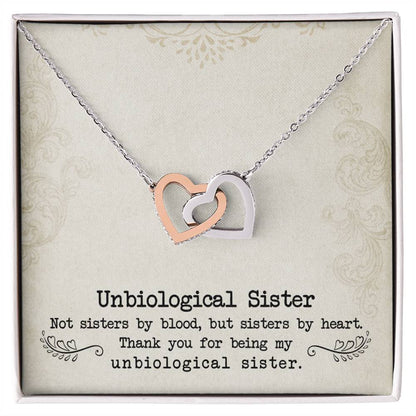 Silver necklace with the To My Unbiological Sister, Sister By Heart - Interlocking Hearts Necklace pendants inlaid with cubic zirconia crystals on a message card for an "unbiological sister" by ShineOn Fulfillment.