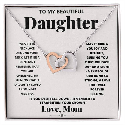 A "To My Daughter, Wear This Necklace - Interlocking Hearts Necklace" with interlocking heart pendants adorned with cubic zirconia crystals on a printed message card from a mother to her daughter, expressing love and encouragement.