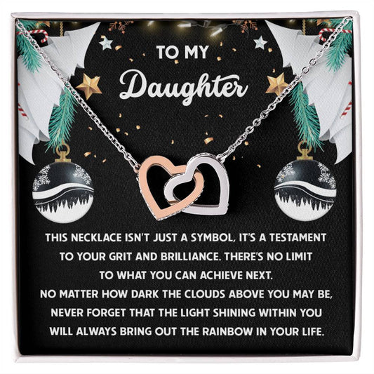 The "Daughter-The Rainbow - Interlocking Hearts Necklace" is adorned with cubic zirconia crystals and comes in a gift box labeled "To My Daughter," surrounded by festive decorations and a heartfelt message.