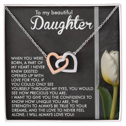 A silver Daughter-Heart Love - Interlocking Hearts Necklace with cubic zirconia crystals is in an open box featuring a loving and confident message for a daughter, alongside an image of a white tulip on the right.
