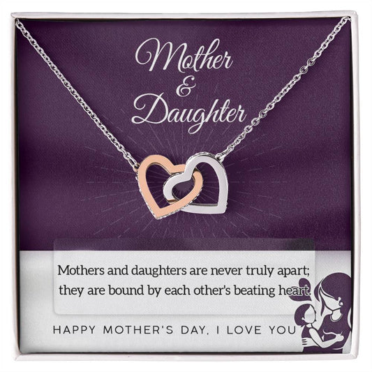 The Mother & Daughter-Never Truly Apart Interlocking Hearts Necklace features a gold and silver heart design with cubic zirconia crystals, presented in a "Mother & Daughter" gift box and comes with a heartfelt message about their unbreakable bond.