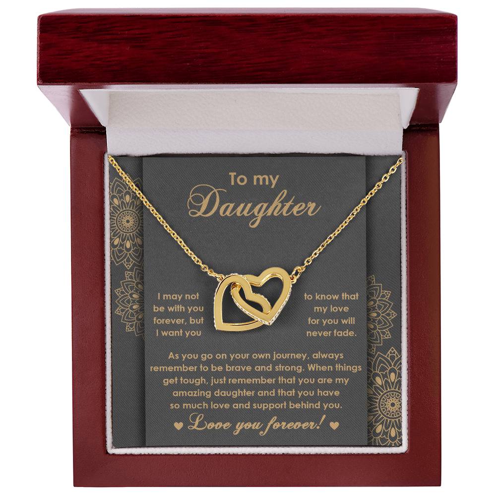 The "To Daughter, Brave And Strong 2 - Interlocking Hearts Necklace" features high-quality polished surgical steel and sparkling cubic zirconia crystals. It is presented on a card adorned with an inspiring message for your daughter, expressing love and encouragement.