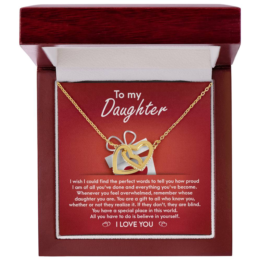 A stunning "To Daughter, A Gift - Interlocking Hearts Necklace" with cubic zirconia crystals is displayed on a red card, featuring a heartfelt message for a daughter, expressing pride, love, and encouragement.