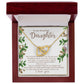 The Daughter-First Smile - Interlocking Hearts Necklace, with surgical steel and rose gold, sits in a red jewelry box. The inner lid features a heartfelt message to a daughter, framed by floral designs.