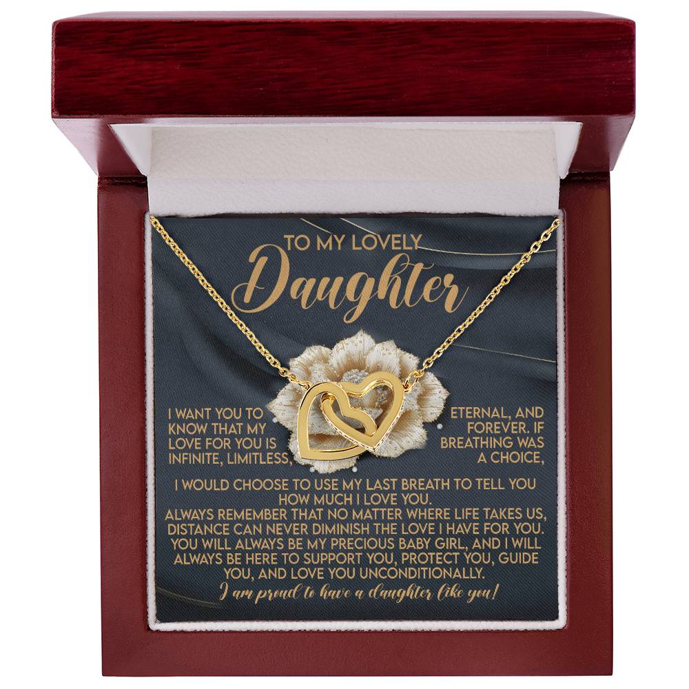 An open jewelry box reveals the "Daughter-Infinite Love - Interlocking Hearts Necklace" in a rose gold finish, featuring two overlapping hearts. Behind it is a heartfelt message to a daughter of eternal love and support. The box's soft, light fabric lining enhances its elegance.