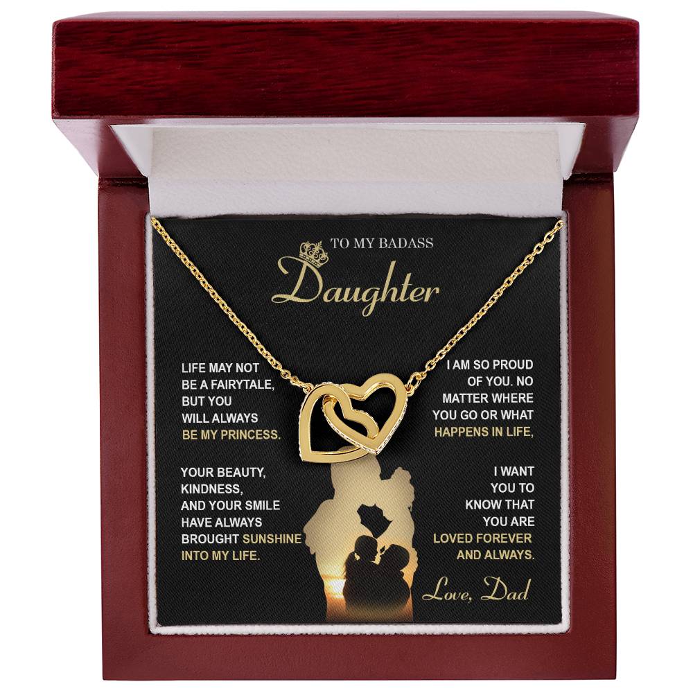 The "To Daughter, Be My Princess - Interlocking Hearts Necklace" with a rose gold finish and adorned with cubic zirconia crystals is displayed in a box that features a heartfelt message from a father to his daughter about love, support, and pride. The text and silhouette of a father and daughter are also included below.