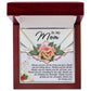 The Mom-Being You - Interlocking Hearts Necklace in rose gold rests in an open red velvet box, inscribed with "To My Mom" and a heartfelt message. Delicate floral designs adorn the background, adding charm.