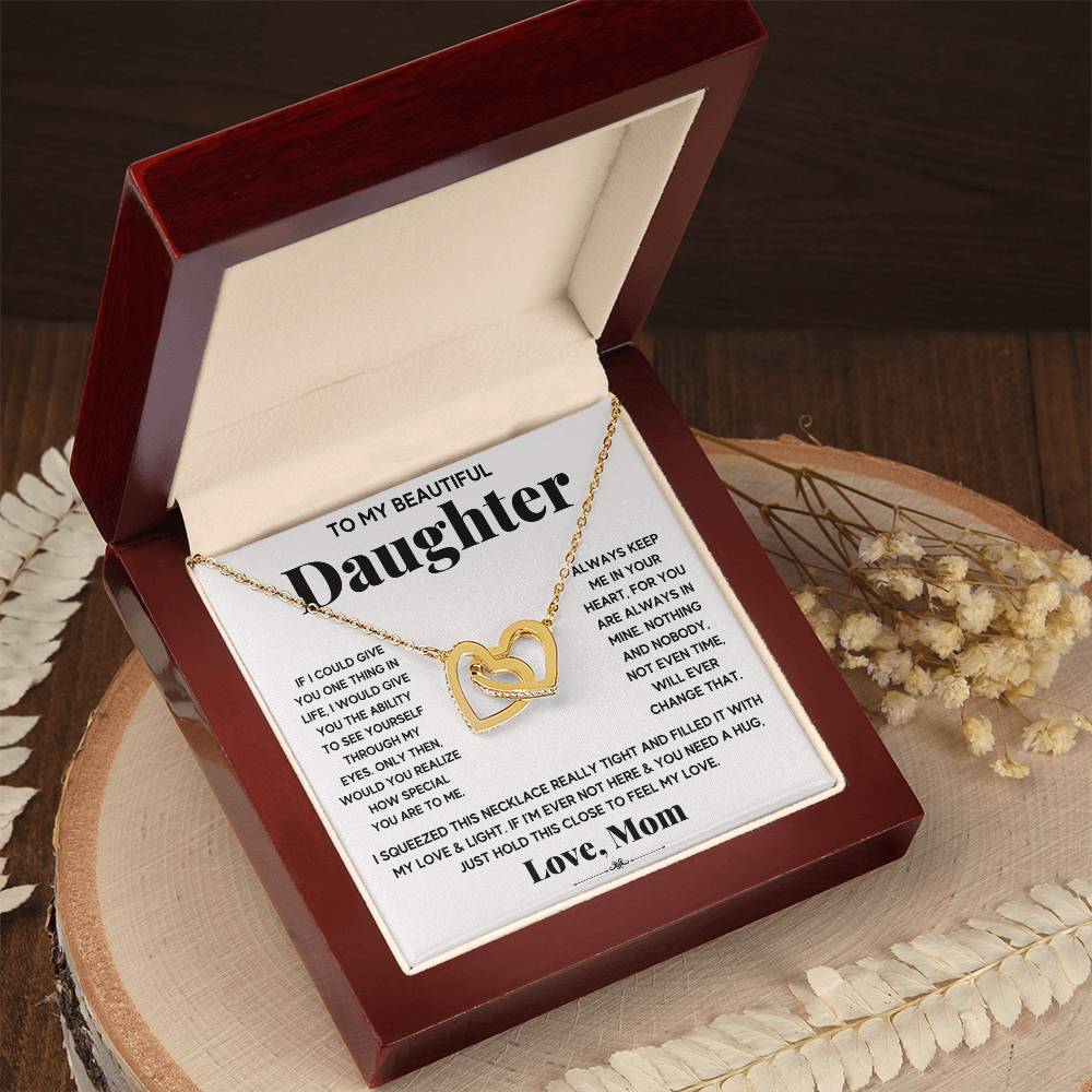 A To My Beautiful Daughter, Just Hold This To Feel My Love - Interlocking Hearts Necklace adorned with cubic zirconia crystals in a gift box with a message from a mother to a daughter by ShineOn Fulfillment.
