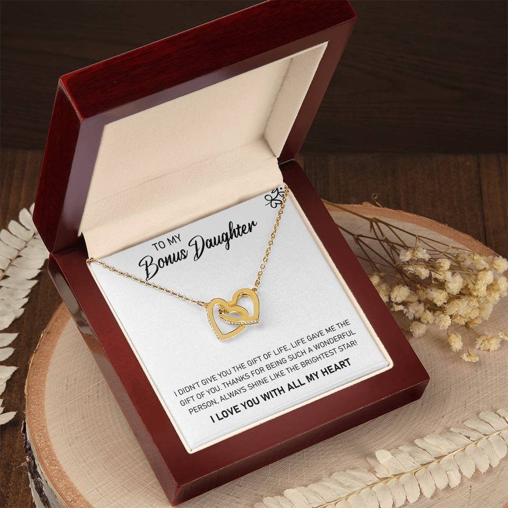 A To My Bonus Daughter, Always Shine Like The Brightest Star - Interlocking Hearts Necklace by ShineOn Fulfillment inside a box featuring a sentimental message for a stepdaughter.