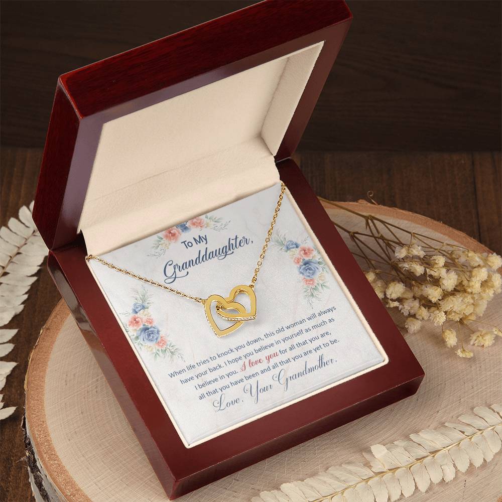 A To My Granddaughter, This Old Woman Will Always Have Your Back - Interlocking Hearts Necklace featuring cubic zirconia crystals inside a gift box, accompanied by a sentimental note from ShineOn Fulfillment to her granddaughter.