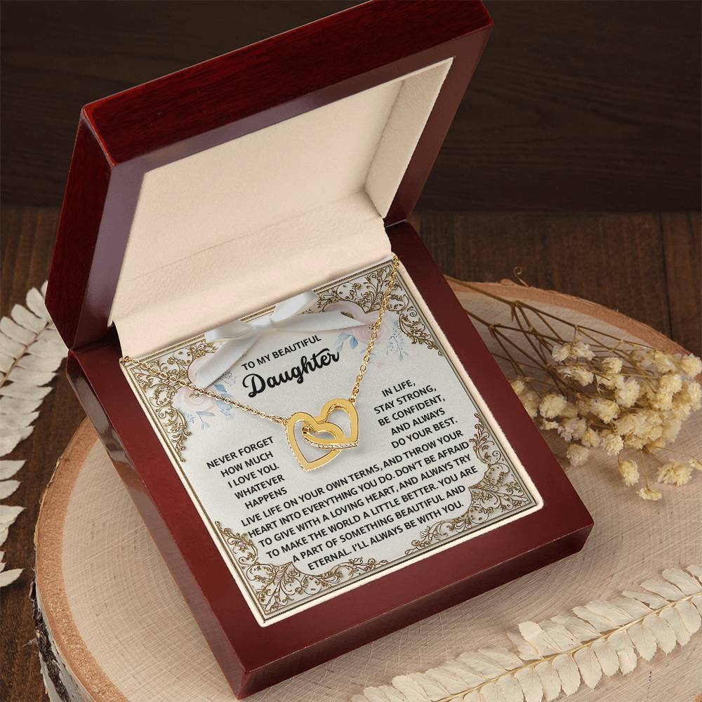 An open wooden box displays the "Daughter-Beautiful And Eternal - Interlocking Hearts Necklace," sparkling with cubic zirconia and a rose gold finish, accompanied by an ornate card carrying an inspirational message for a daughter.