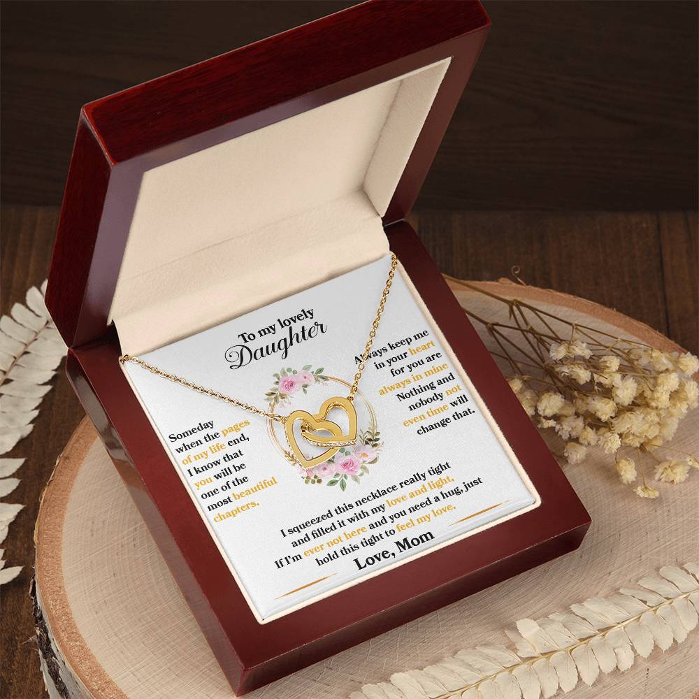 A heart-shaped, interlocking hearts pendant necklace in a gift box with a sentimental message for a daughter from a mother. 
Product Name: To My Lovely Daughter, Hold This Tight To Feel My Love - Interlocking Hearts Necklace 
Brand Name: ShineOn Fulfillment