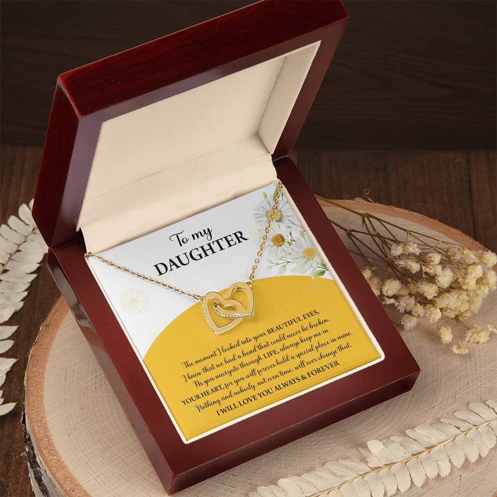 A box contains a "To Daughter, A Special Place - Interlocking Hearts Necklace" with cubic zirconia crystals. The message reads: "To my Daughter... Always keep me in your heart... Nothing brings me more joy than you. I will love you always & forever.