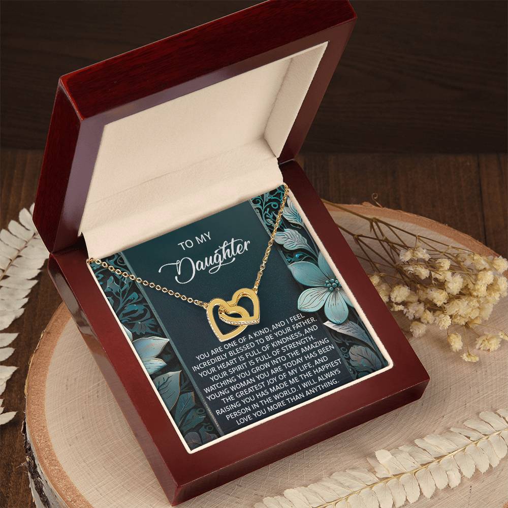 The Daughter-Happiest Person Interlocking Hearts Necklace features a rose gold finish and cubic zirconia crystals. It is beautifully presented in a wooden box with a card titled "To My Daughter" that conveys a heartfelt message.
