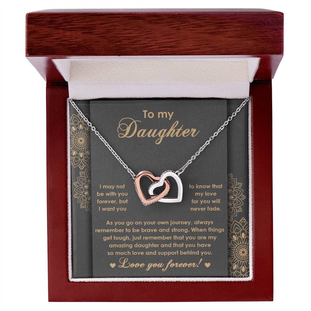 The "To Daughter, Brave And Strong 2 - Interlocking Hearts Necklace" features high-quality polished surgical steel and sparkling cubic zirconia crystals. It is presented on a card adorned with an inspiring message for your daughter, expressing love and encouragement.