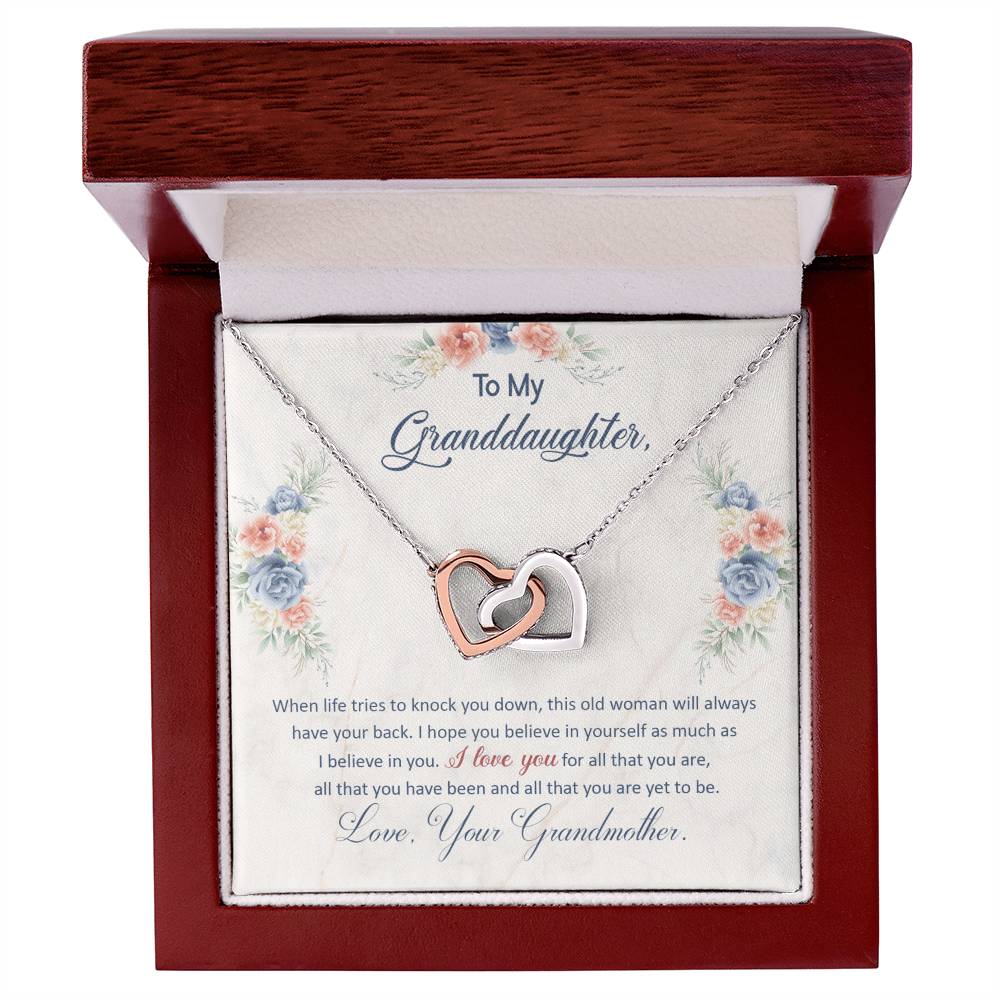 A "To My Granddaughter, This Old Woman Will Always Have Your Back - Interlocking Hearts Necklace" featuring interlocking hearts in a gift box with a loving message from grandmother to granddaughter by ShineOn Fulfillment.