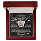The Daughter-Your Strength Interlocking Hearts Necklace, featuring heart pendants with a silver and rose gold finish adorned with sparkling cubic zirconia crystals, is elegantly presented in a wooden box. Inside, a heartfelt card offers a supportive message about love and resilience to a daughter.