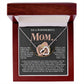 The Mom-More To Me 2 - Interlocking Hearts Necklace with an 18k yellow gold finish sparkles inside an open jewelry box, paired with a card expressing deep gratitude and love for a mother’s support, compassion, and daily acts of kindness.