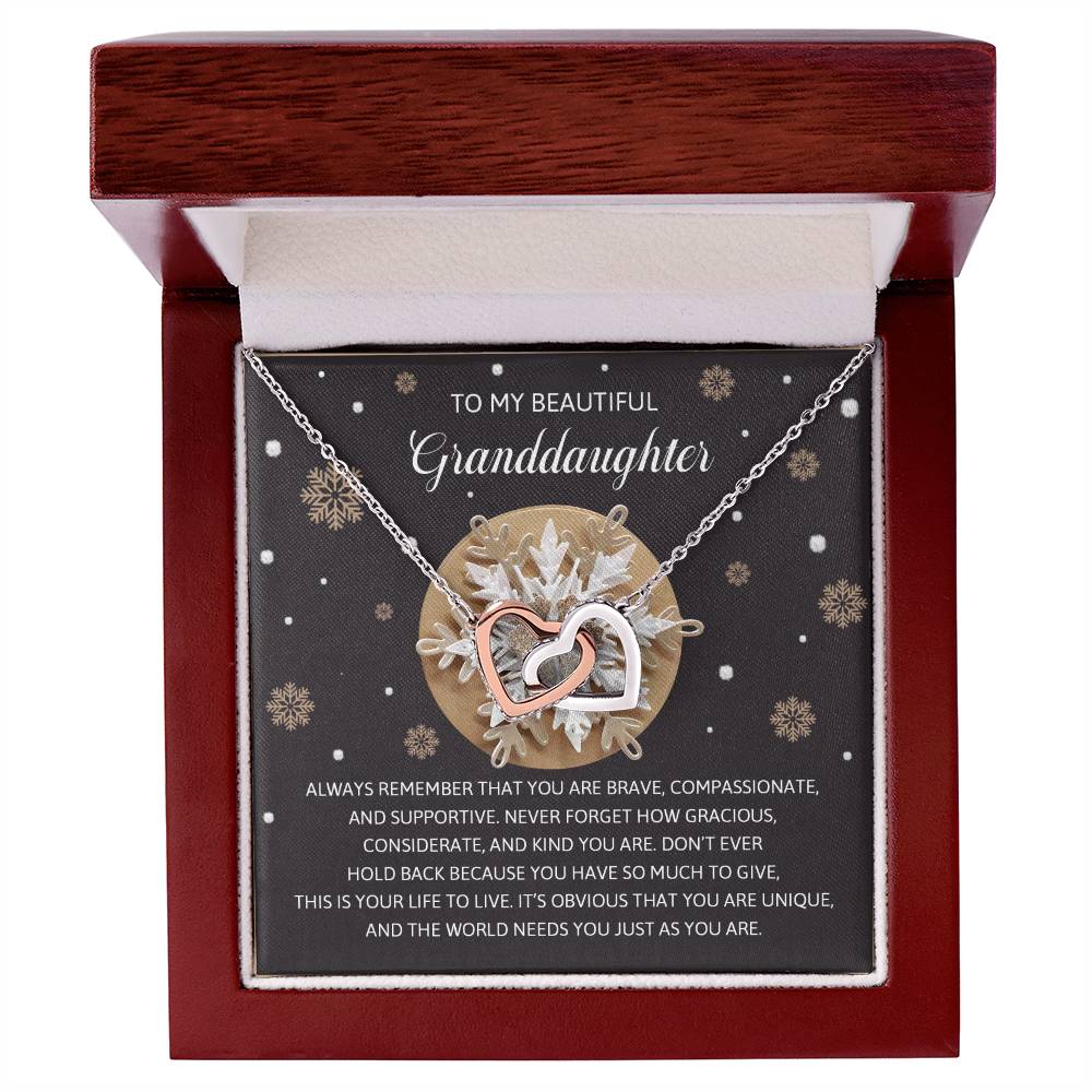 The Granddaughter-As You Are - Interlocking Hearts Necklace comes in a delightful gift box labeled "Granddaughter," adorned with sparkling cubic zirconia crystals and finished in rose gold, complete with a touching message honoring bravery and individuality.