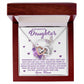 The Daughter-Angel Heart necklace, featuring a rose gold finish and cubic zirconia crystals, is presented in a wood box with the message, "To my beautiful daughter, remember that you are the angel that God sent into my life... Love, Mom," against a backdrop of flowers and butterflies.