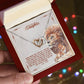 A hand holding an anniversary gift box with a ShineOn Fulfillment To My Beautiful Daughter, I Promise To Love You For The Rest Of My Life - Interlocking Hearts Necklace and an emotional message to a daughter from a father, featuring lion imagery.
