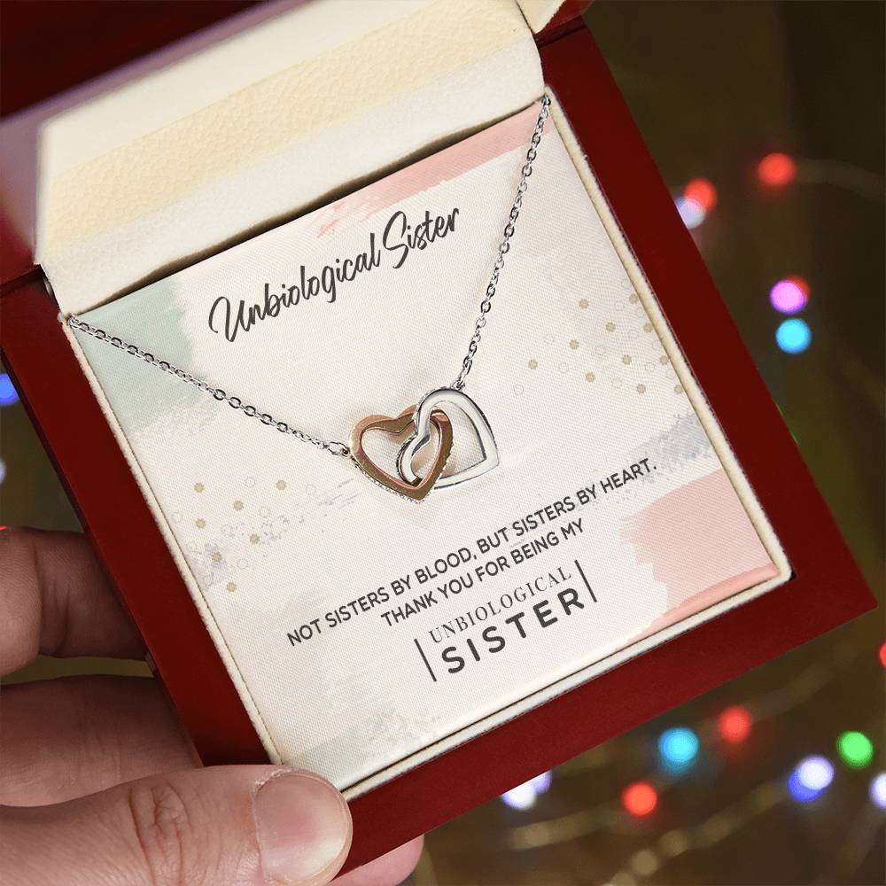 A To My Unbiological Sister, Thank You - Interlocking Hearts Necklace by ShineOn Fulfillment featuring interlocking hearts and cubic zirconia crystals, inside a box with an inscription expressing sisterhood by heart, not by blood.