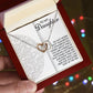 A hand presents an open gift box with the Daughter-Tomorrow Worry - Interlocking Hearts Necklace, featuring a rose gold finish and cubic zirconia. A message titled "To My Daughter" reassures her of her abilities and the parent's support, set amid colorful, blurred lights.