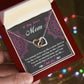 An open gift box reveals the "Bonus Mom-An Amazing Mom - Interlocking Hearts Necklace," featuring cubic zirconia crystals and a rose gold finish. Inside the lid, "To My Bonus Mom" is written in pink on a black backdrop with decorative pink floral patterns.