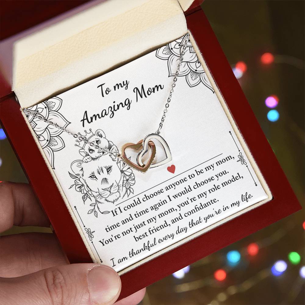 The "To Mom, Be My Mom - Interlocking Hearts Necklace" is beautifully presented in a floral-adorned box with glimmering cubic zirconia crystals, featuring a heartfelt message to "Amazing Mom," making it a unique gift.