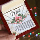 A hand presents an open jewelry box showcasing the "Mom-Being You - Interlocking Hearts Necklace." Inside, a floral design complements a heartfelt message thanking a mother for her love, support, and strength.