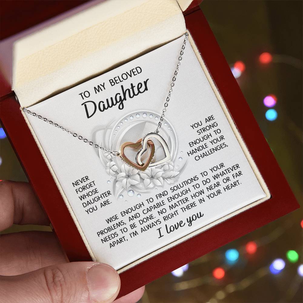 The "To Daughter, Always Right There - Interlocking Hearts Necklace" features a stunning interlocking hearts design with a rose gold finish and sparkling cubic zirconia crystals. It comes in a gift box that includes a heartfelt message for your beloved daughter, offering support, wisdom, and love.