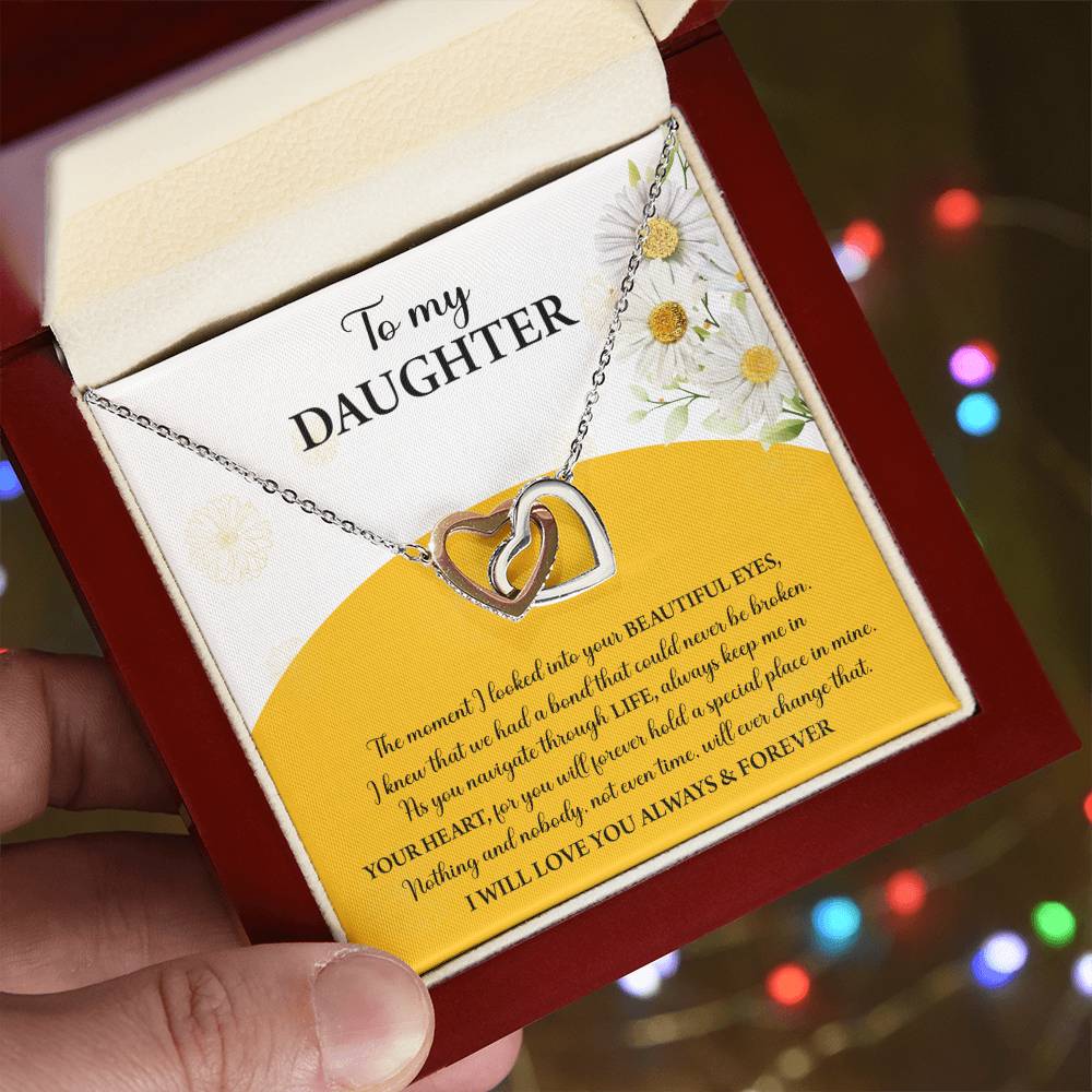 A box contains a "To Daughter, A Special Place - Interlocking Hearts Necklace" with cubic zirconia crystals. The message reads: "To my Daughter... Always keep me in your heart... Nothing brings me more joy than you. I will love you always & forever.