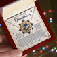 A hand holds an open red jewelry box with the Daughter-Precious Gift - Interlocking Hearts Necklace, featuring a rose gold finish and sparkling cubic zirconia crystals. Behind it is a heartfelt message for a daughter, expressing love and encouragement.