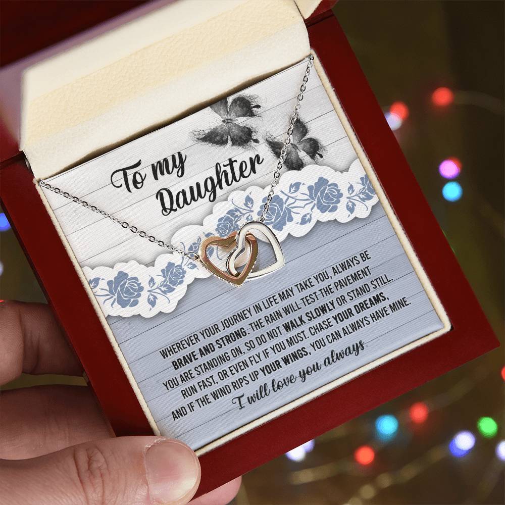 The "To Daughter, Always Have Mine - Interlocking Hearts Necklace," adorned with cubic zirconia crystals, is beautifully presented against a decorative card that inspires bravery, strength, and the pursuit of dreams. The message is addressed "To my Daughter" and concludes with "I will love you always.