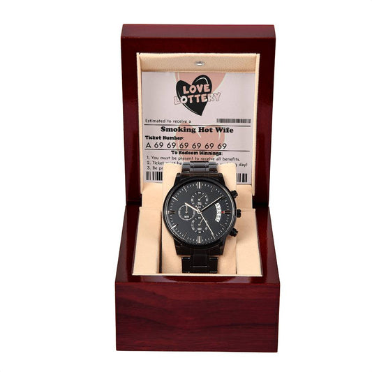 A black "To Husband, Jackpot Winner - Metal Chronograph Watch" displayed in an open wooden box. Behind the watch is a card with the text "Love Lottery" and "Smoking Hot Wife.