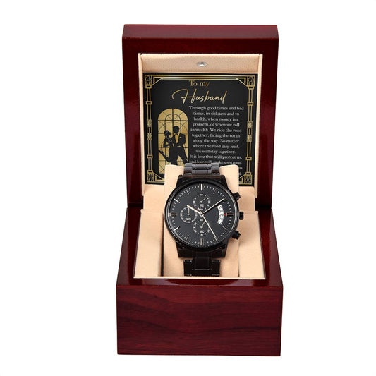 A black chronograph watch with multiple dials is displayed inside a wooden box. A message card titled "To Husband, Make Us Strong - Metal Chronograph Watch" is placed beside it.