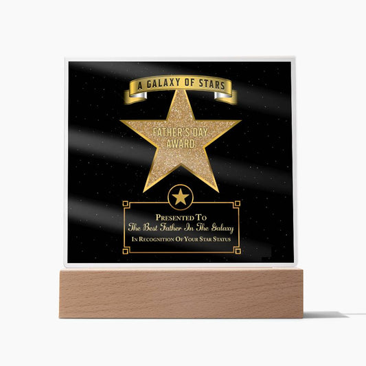 A trophy with an LED wooden base and a black plaque featuring a gold star and text that reads, "To Dad, Galaxy Of Stars - Acrylic Square Plaque." This sentimental gift is perfect for honoring your dad.