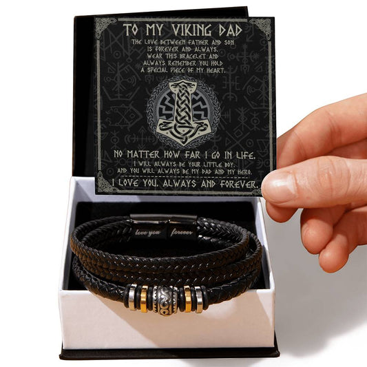 A hand holding a card with a message "To My Viking Dad" above a black vegan leather braided men's bracelet with metal beads and an engraved message in an open box.