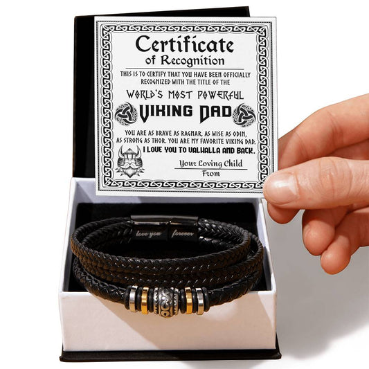 A hand holds a gift box containing a To Dad, The Viking Dad - Love You Forever Bracelet with metal beads, alongside a "world's most powerfully punishing dad" certificate.
