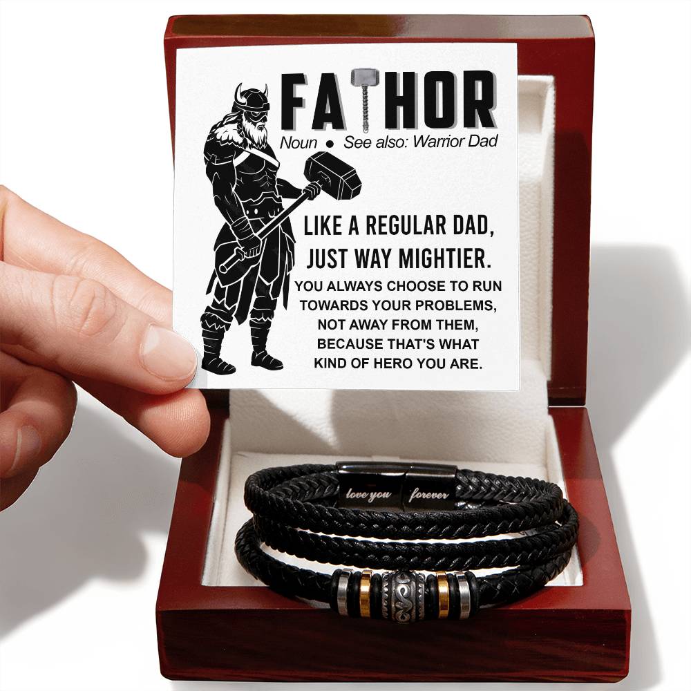 A hand presents an open gift box containing a To Dad-Warrior Dad - Love You Forever Bracelet with metal accents, next to a card describing the word "fathor" as a play on "father" and "Thor.
