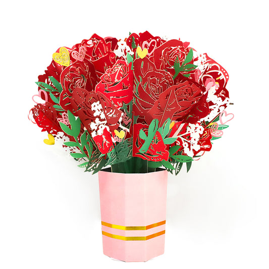 The Sweet Devotion Flower Bouquet features a large displayable decoration of red paper roses with green stems and white accents, all arranged in a pink vase with gold bands. This charming bouquet never wilts, offering everlasting beauty to any room.