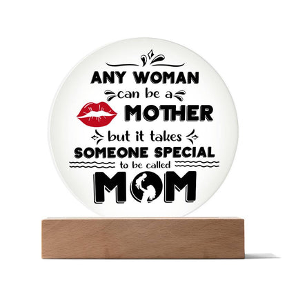 Round To Mom, Someone Special Acrylic Circle Plaque with printed text "any woman can be a mother but it takes someone special to be called mom" and decorative elements including lips and floral patterns, mounted on a wooden LED base.