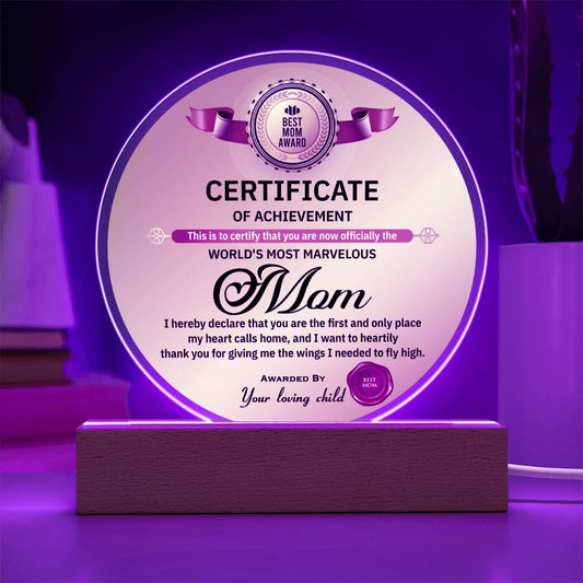 Acrylic plaque award titled "Best Mom Award" on a wooden base, illuminated by purple light, certifying the recipient as the "To Mom, World's Most Marvelous Mom".