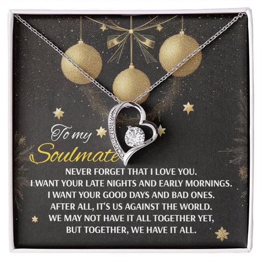 The Soulmate-Have It All - Forever Love Necklace features a heart-shaped pendant with a cubic zirconia center, presented on a card that reads, "To my Soulmate," along with an affectionate message. It is beautifully showcased against a background adorned with golden ornaments.