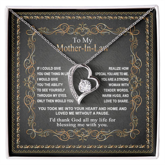 A "To Mother-In-Law, Through My Eyes - Forever Love Necklace" featuring a heart-shaped pendant with a crystal on a chain, displayed in a black box with a sentimental message.