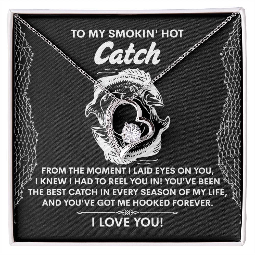 Heart-shaped Forever Love Necklace with a diamond and gold finish, featuring two fish. Comes in a black box with the message: "To my smokin' hot catch... I love you!" Product Name: Soulmate-Got Me Hooked - Forever Love Necklace.