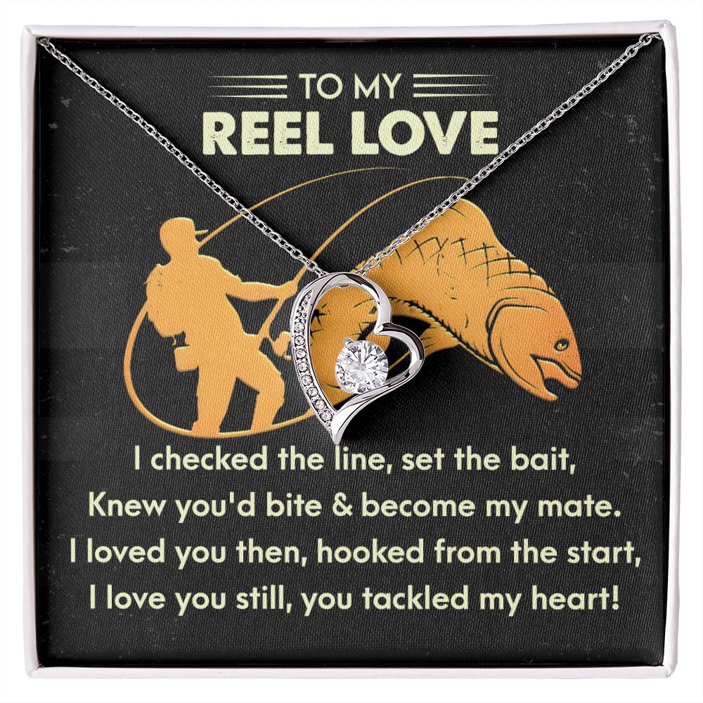 The Soulmate-Tackled My Heart - Forever Love Necklace, featuring a heart pendant with sparkling cubic zirconia crystals, is elegantly presented in a box with text about love and fishing.