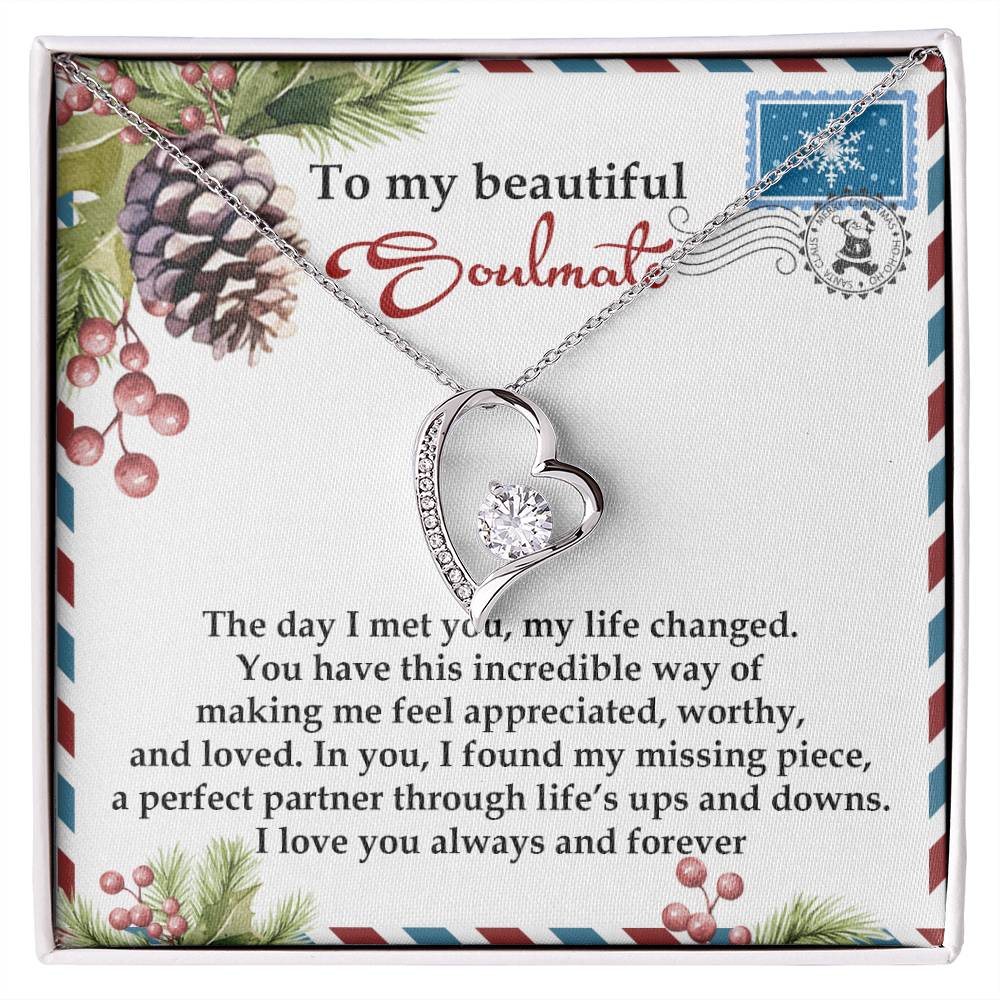 The Soulmate-Perfect Partner - Forever Love Necklace, featuring a heart and CZ crystal pendant, is presented on a card with a heartfelt message to your soulmate. It is beautifully framed by a pine and holly border design and elegantly finished in gold.